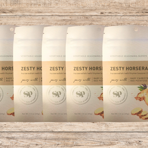 Five packs of Zesty Horseradish Vegetable Seasoning blend with horseradish, lime, and thyme on a rustic wooden background.