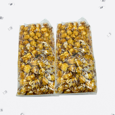 Two-pack of Sugar Plum's handcrafted caramel corn with white and milk chocolate drizzle in clear packaging.