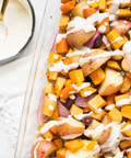 Roasted vegetables with creamy sauce featuring potatoes, carrots, and onions in a baking dish, perfect for a zesty horseradish seasoning.